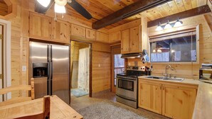 A wooden cabin kitchen with a refrigerator, stove, sink, and wooden cabinets. - Near Hiking & Golfing: Munds Park Cabin w/ Deck! (Munds Park)