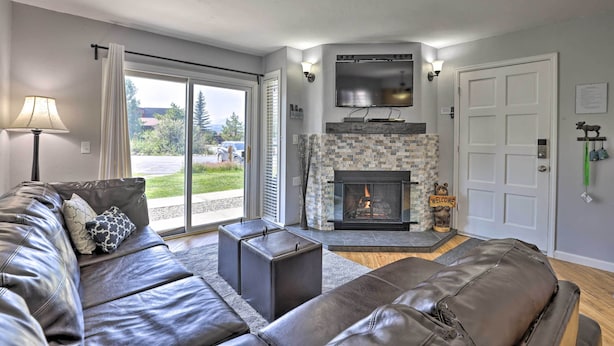 A modern living room with a leather sofa, a fireplace, and a television mounted above it. - Luxe Fraser Condo: Community Pool and Hot Tub Open (Fraser)
