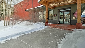 A building with a wooden facade and a sign reading "Club Meadow Ridge." - Luxe Fraser Condo: Community Pool and Hot Tub Open (Fraser)