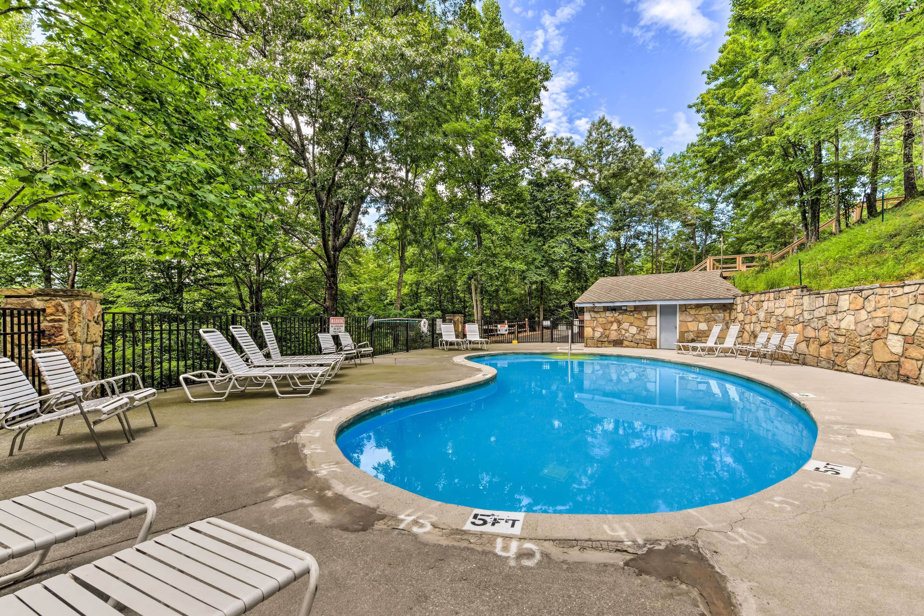 A swimming pool with lounge chairs and a stone wall.