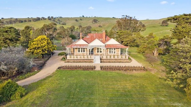 A large, two-story house with a red roof, surrounded by a well-maintained lawn and trees. - Restored Luxury Historic Glenroy Homestead (Mansfield)
