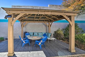 A wooden pergola with a table and blue chairs underneath. - Williams Studio on Famous Route 66 With Fireplace! (Williams)