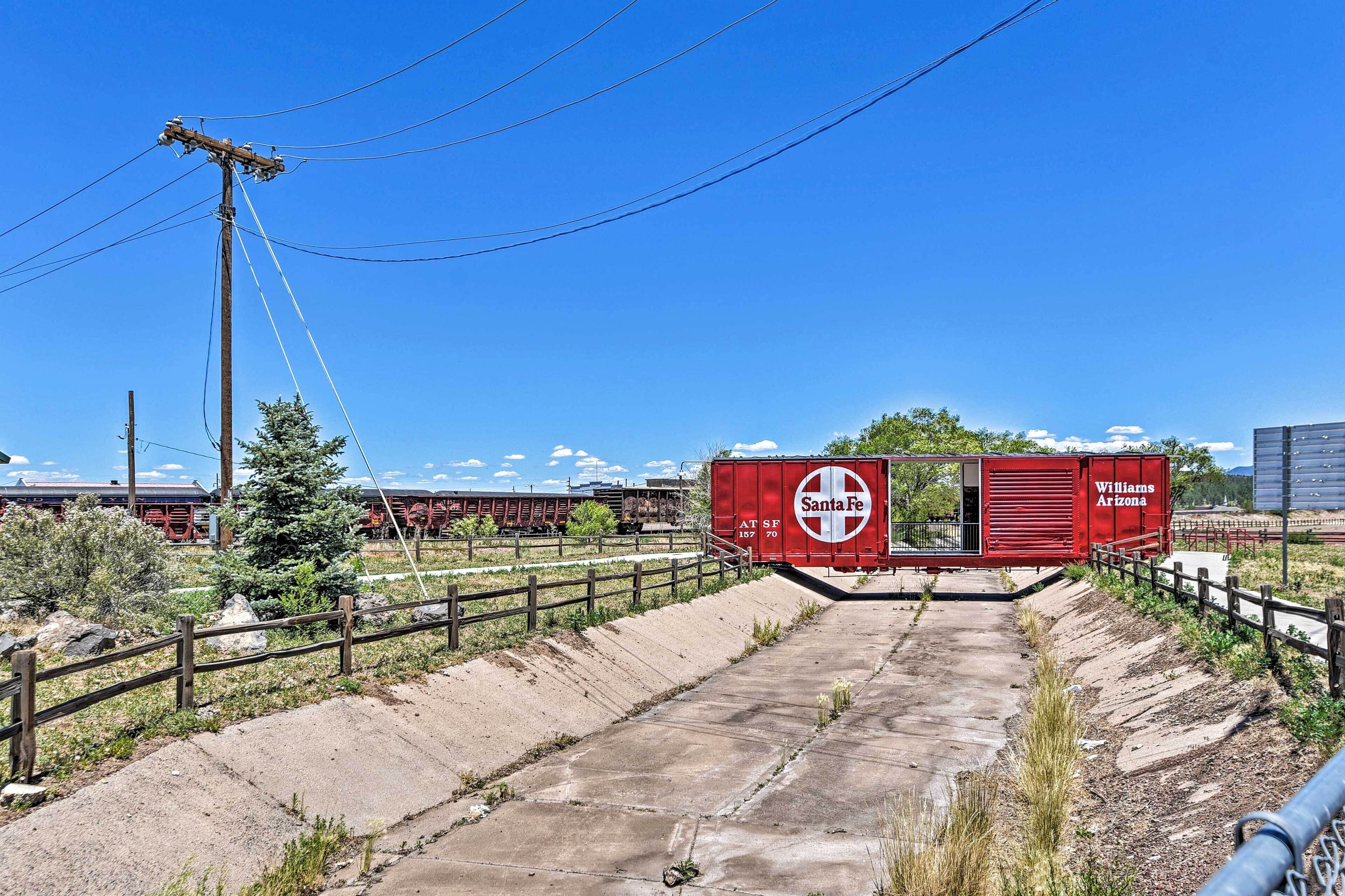 A railway crossing with a red Santa Fe Williams Arizona train car.