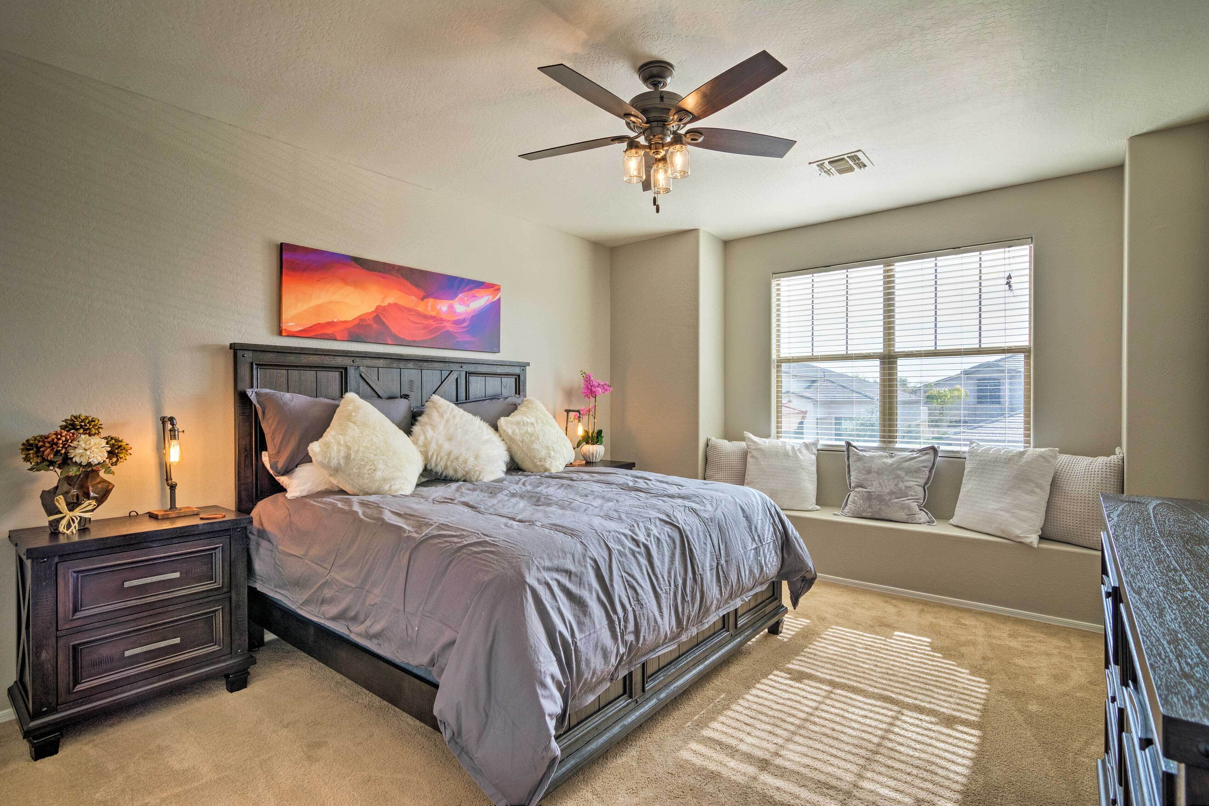 A bedroom with a bed, nightstand, and window seat.