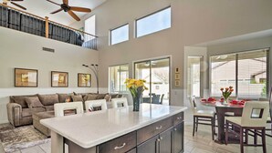 A spacious kitchen with a large island, a dining area with a glass table, and a cozy seating area with a sofa and chairs. - Group Fun in Glendale! Getaway w/ Private Pool (Glendale)
