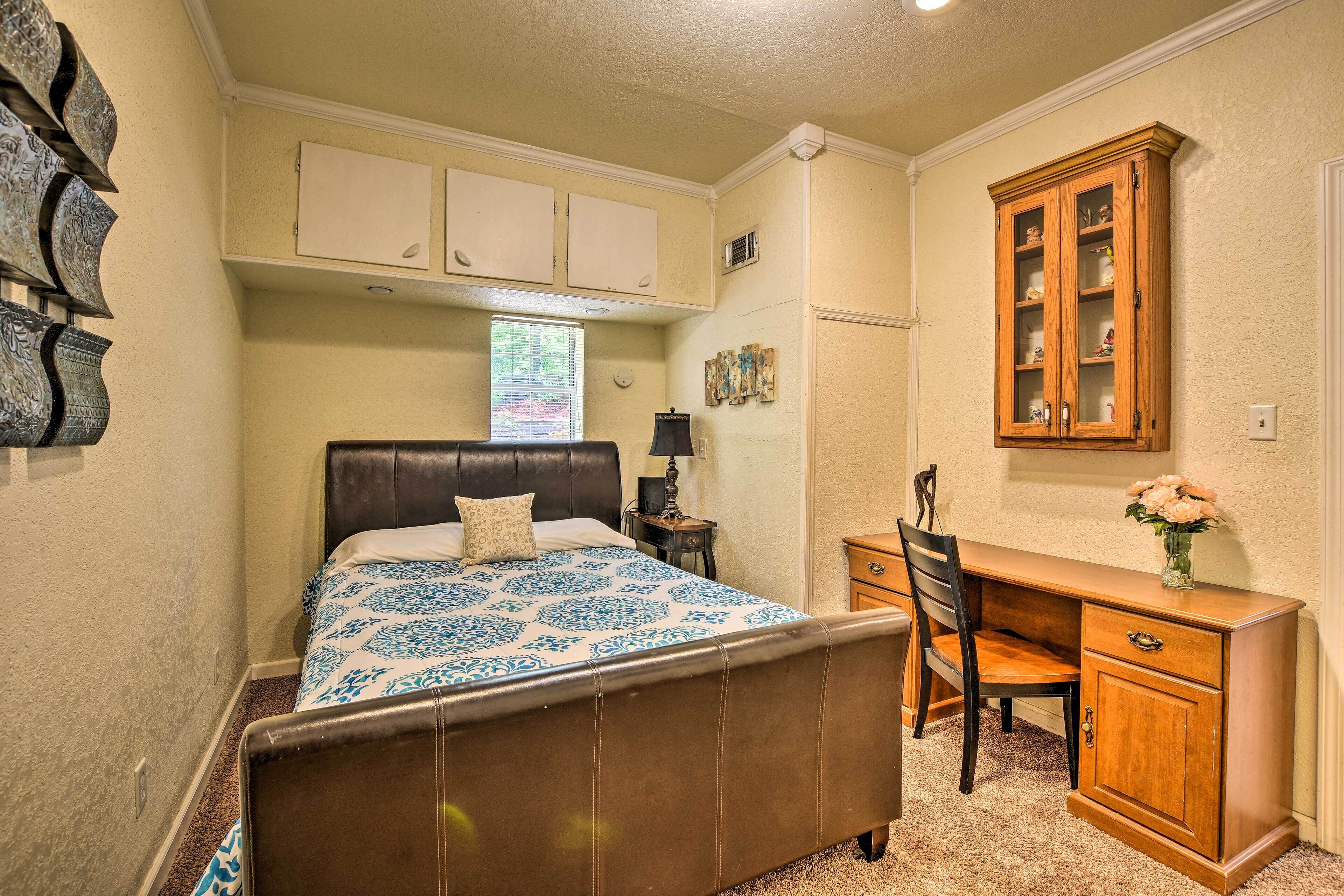 Een slaapkamer met een bed, een bureau en een kast.