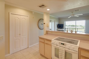 A kitchen with a stove, oven, and a clock on the wall.