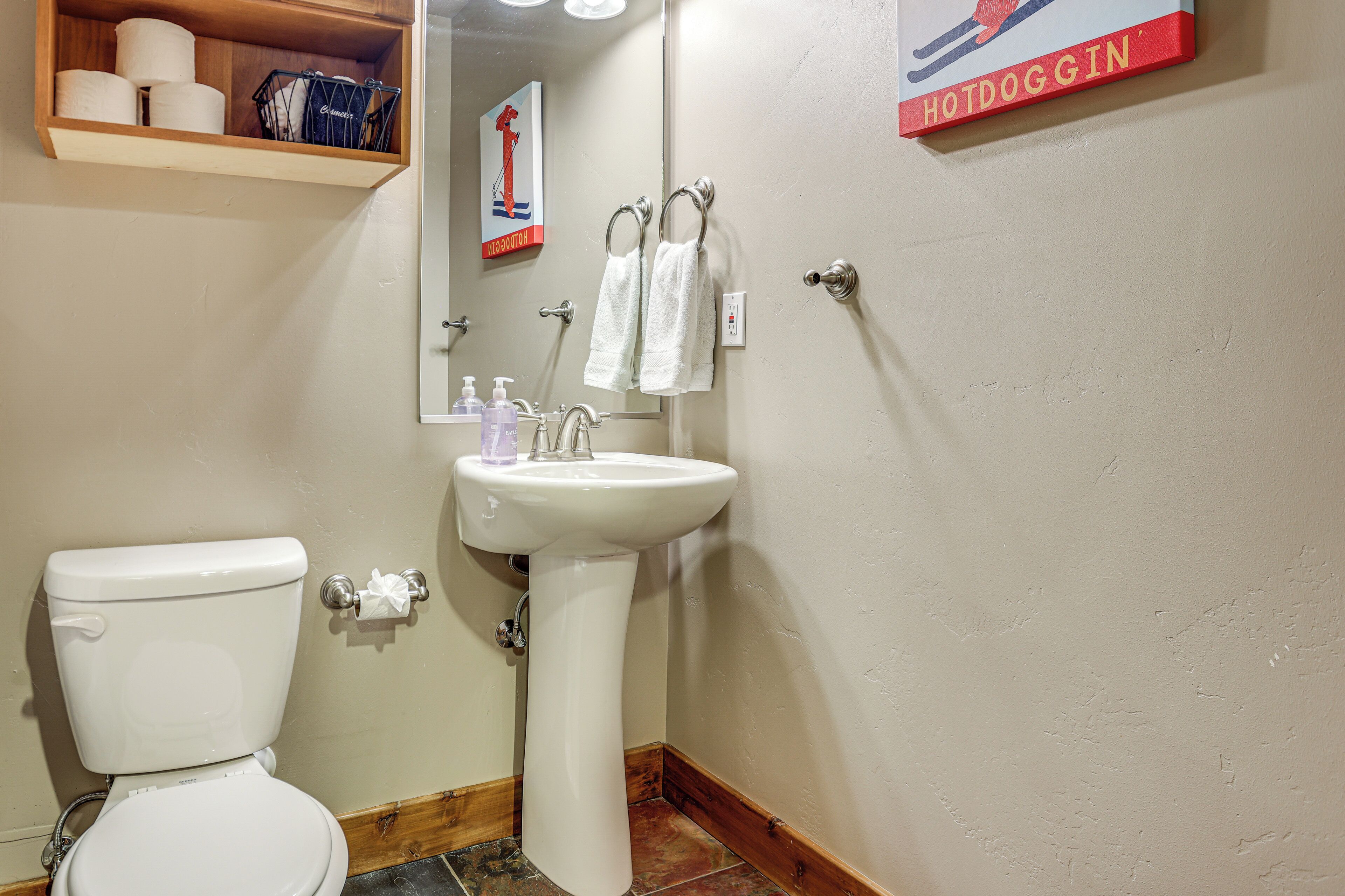 Une salle de bain équipée de toilettes, d’un lavabo et d’un porte-serviettes.