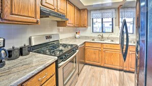 A kitchen with wooden cabinets, a stainless steel stove, and a refrigerator.