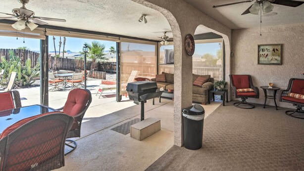 An open-plan living area with a patio, ceiling fans, and a view of the outdoors.