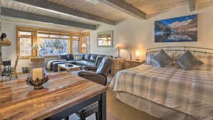 A cozy bedroom with a bed, a sofa, and a wooden table with a candle. - Pool + Hot Tub Access! Ski Lovers Studio (Snowmass Village)