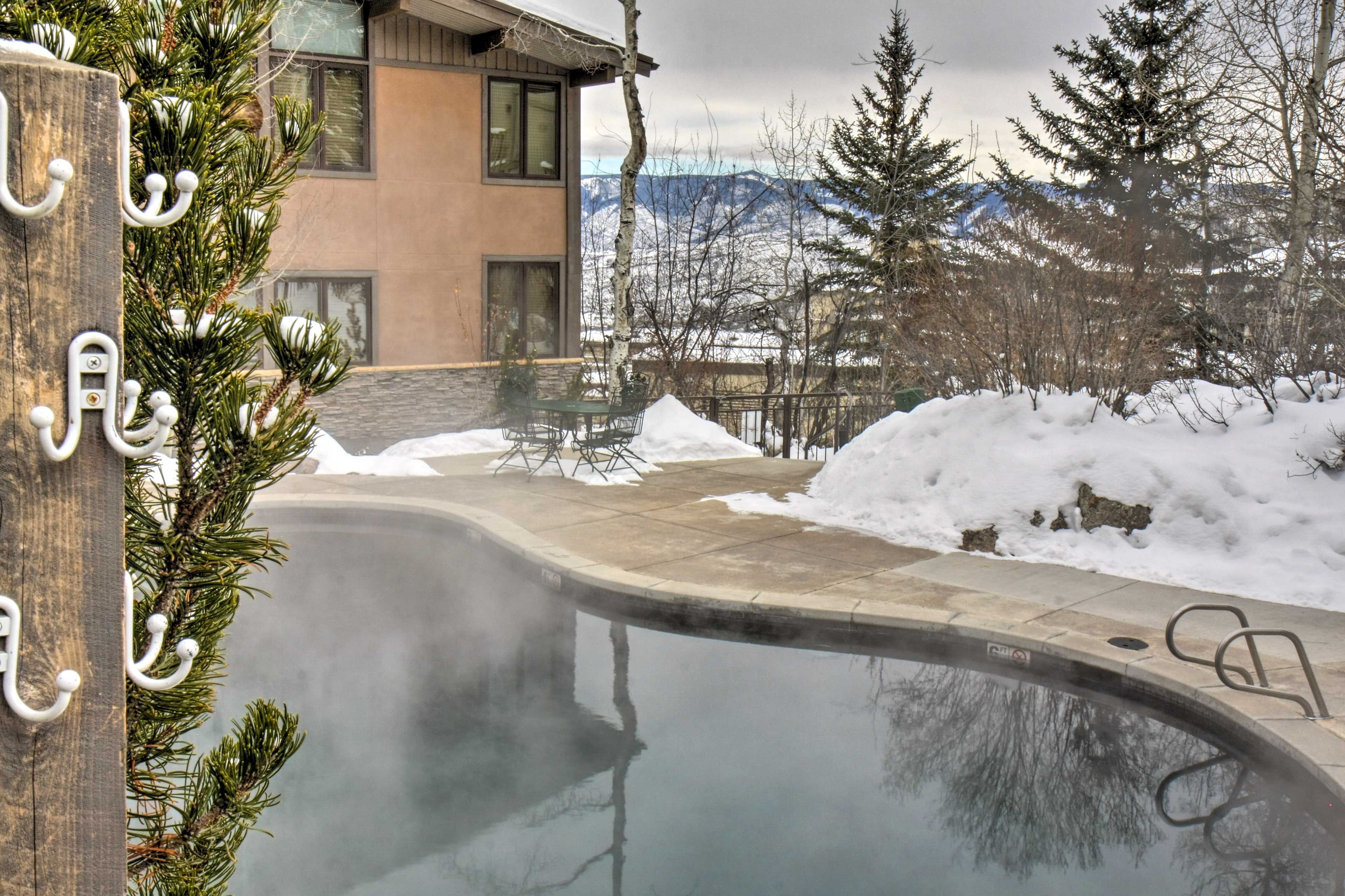 Ein Schwimmbecken mit Holzterrasse und verschneitem Grund.