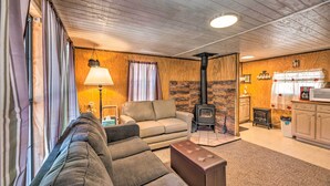 Ein gemütliches Wohnzimmer mit einer Couch, einem Hocker und einem Kamin.