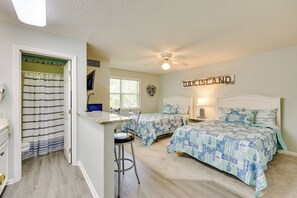 Un dormitorio con dos camas, un ventilador de techo, una ventana y un letrero que dice "OAK ISLAND".