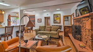 A spacious living area with a sofa, leather chairs, a coffee table, and a stone fireplace. - Patio & Views: Peaceful Sedona Getaway! (Sedona)