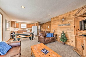 Ein gemütliches Wohnzimmer mit einem braunen Ledersofa, einem Holztisch und einer kleinen Weihnachtstanne.