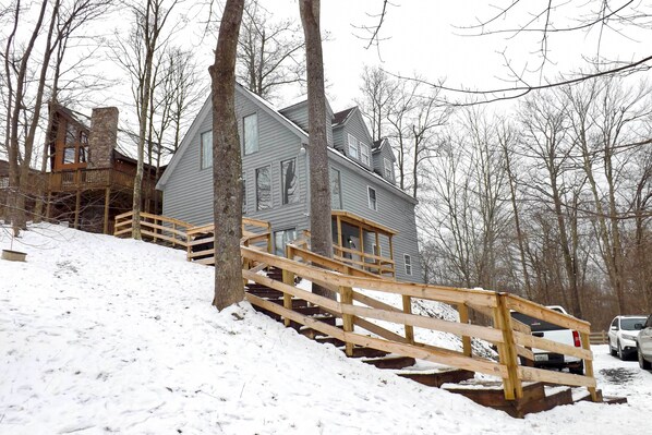 Ein zweistöckiges Haus mit einer Holztreppe, die zur Haustür führt.