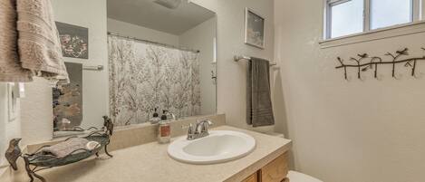 A bathroom with a sink, mirror, and toilet.