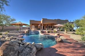 Una casa moderna con piscina, mobiliario exterior y zona de patio.