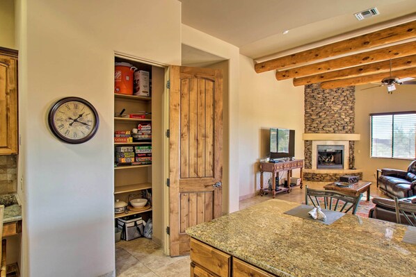 A kitchen with granite countertops, wooden cabinets, and a stone fireplace. - Scottsdale Home: Pickleball, Heated Pool & Hot Tub (Scottsdale)