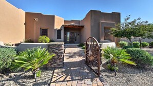 A building with a stucco exterior, a stone pathway, and a metal gate. - Scottsdale Home: Pickleball, Heated Pool & Hot Tub (Scottsdale)
