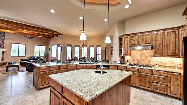 A spacious kitchen with wooden cabinets, a large island, and pendant lighting. - Scottsdale Home: Pickleball, Heated Pool & Hot Tub (Scottsdale)