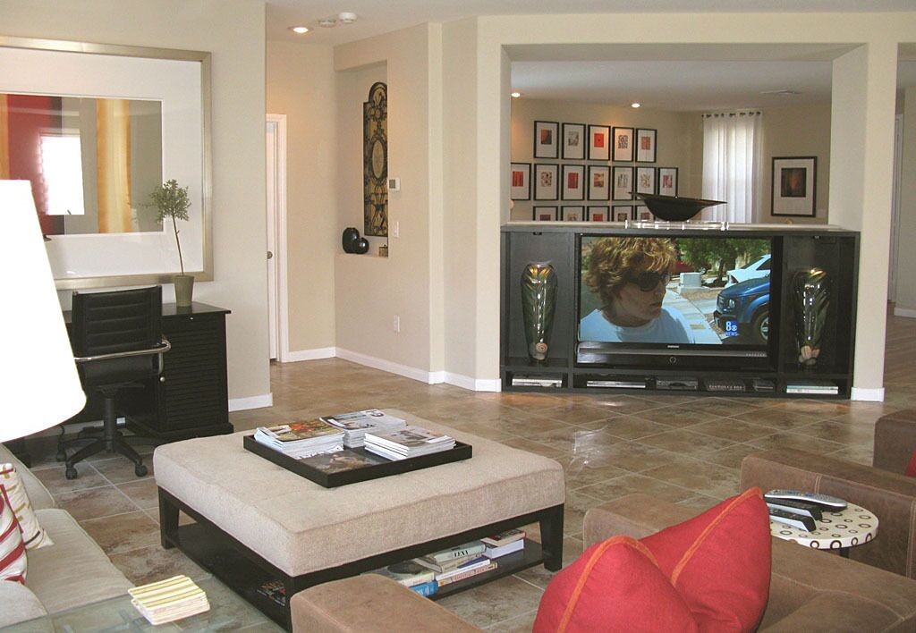 A living room with a television, sofa, ottoman, and coffee table.