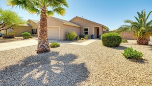 A residential house with a gravel driveway, palm trees, and various shrubs. - Backyard Oasis: Updated San Tan Valley Escape (San Tan Valley)