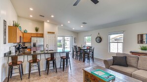 A spacious kitchen with a dining area, a living room with a sofa, and a coffee table. - Backyard Oasis: Updated San Tan Valley Escape (San Tan Valley)
