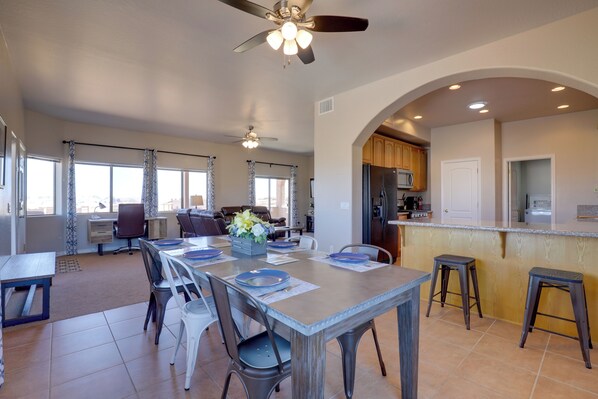 A spacious kitchen with a dining area, a bar, and a seating area with a view. - 3 Mi to Lake Powell: Pet-friendly Page Home (Page)