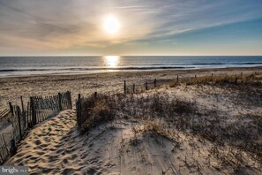 Ein Strand mit einer Holzzaun und Dünen.