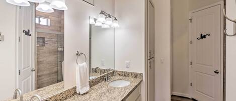 A bathroom with a granite countertop, two sinks, a large mirror, and a sign reading "POWER ROOM".