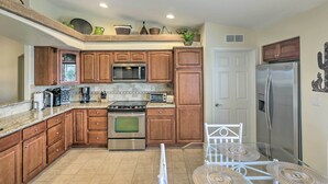A compact kitchen with wooden cabinets, a microwave, a stove, and a refrigerator. - Arizona Retreat w/ Casita ~ 2 Mi to Lake Havasu (Lake Havasu City)