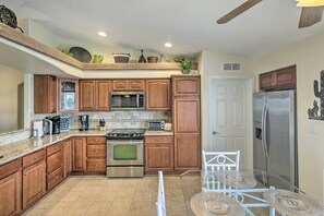 A compact kitchen with wooden cabinets, a microwave, a stove, and a refrigerator. - Arizona Retreat w/ Casita ~ 2 Mi to Lake Havasu (Lake Havasu City)