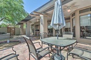 An outdoor patio area with a table and chairs, a ceiling fan, and a large umbrella. - 6 Mi to Dtwn Mesa! Pueblo Retreat w/ Patio (Mesa)