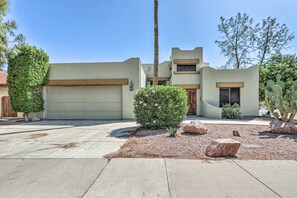 A modern two-story house with a garage, a small garden with rocks and a cactus, and a tall palm tree. - 6 Mi to Dtwn Mesa! Pueblo Retreat w/ Patio (Mesa)