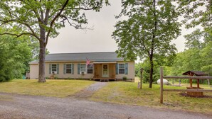 A single-story house with a front porch, a gravel driveway, and a picnic table in the yard. - Spacious Wellston Home Near Hiking & Skiing! (Wellston)