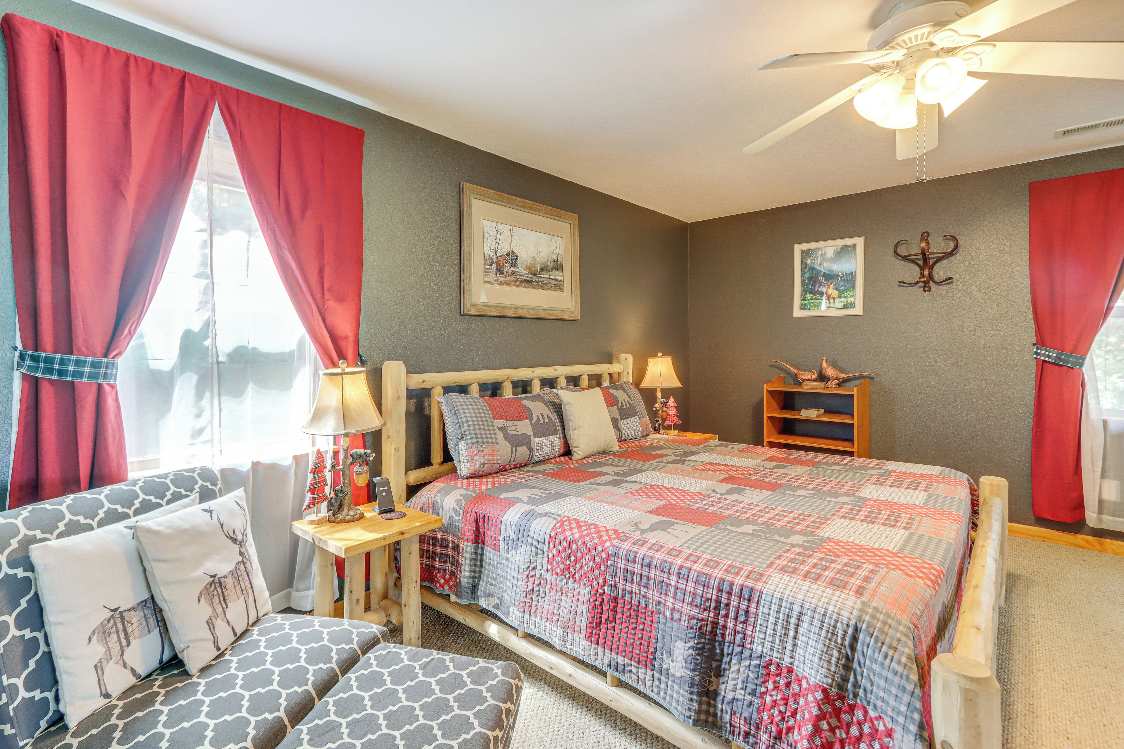 A bedroom with a bed, a nightstand, a lamp, a chair, and a ceiling fan.