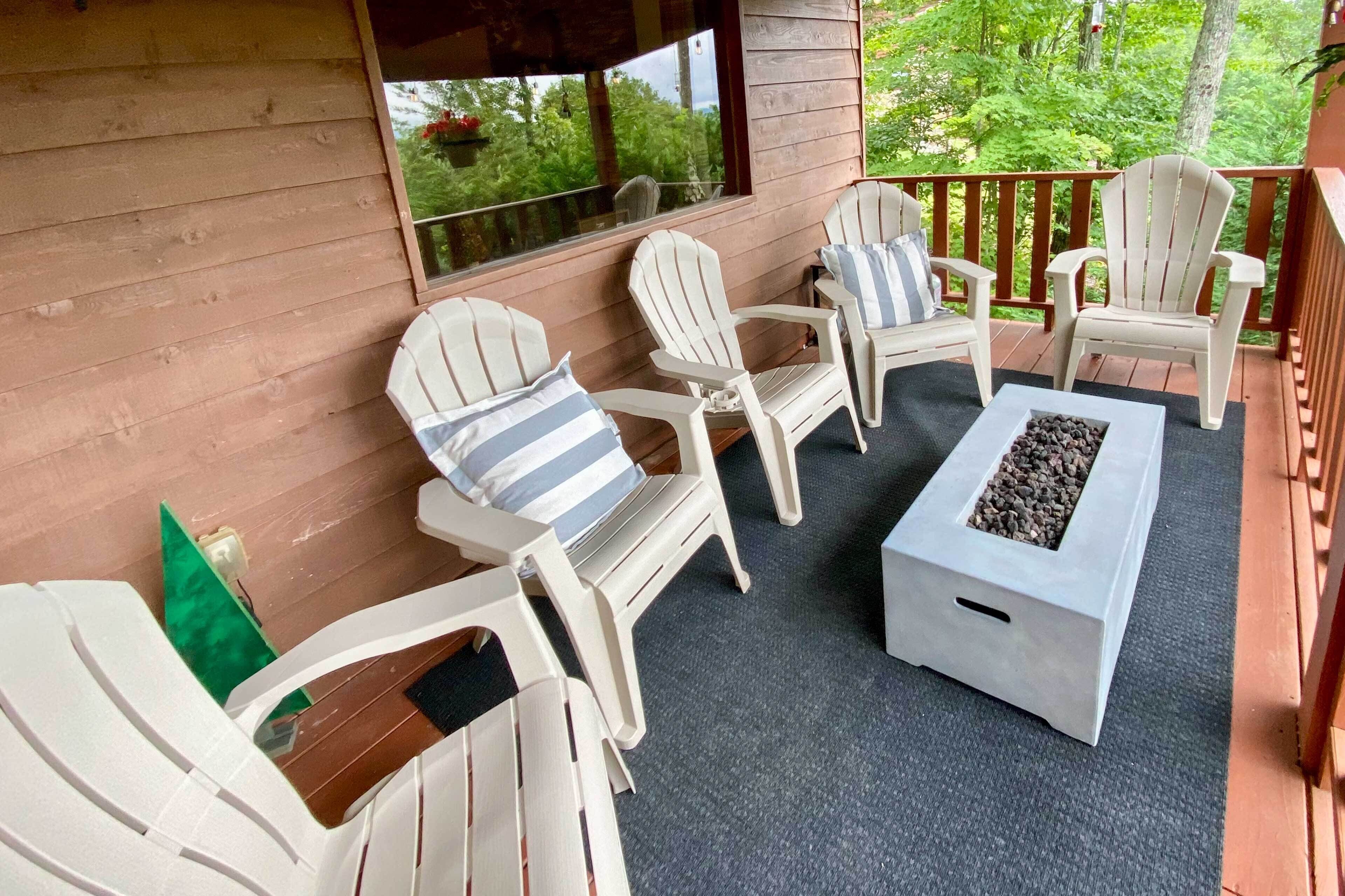 Ein überdachter Außenbereich mit Adirondack-Stühlen und einem Feuerkorb.