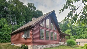 A log cabin with a stone foundation, large windows, and a sloped roof. - Cozy Family-friendly Pine Grove Cabin w/ Fire Pit! (Pine Grove)