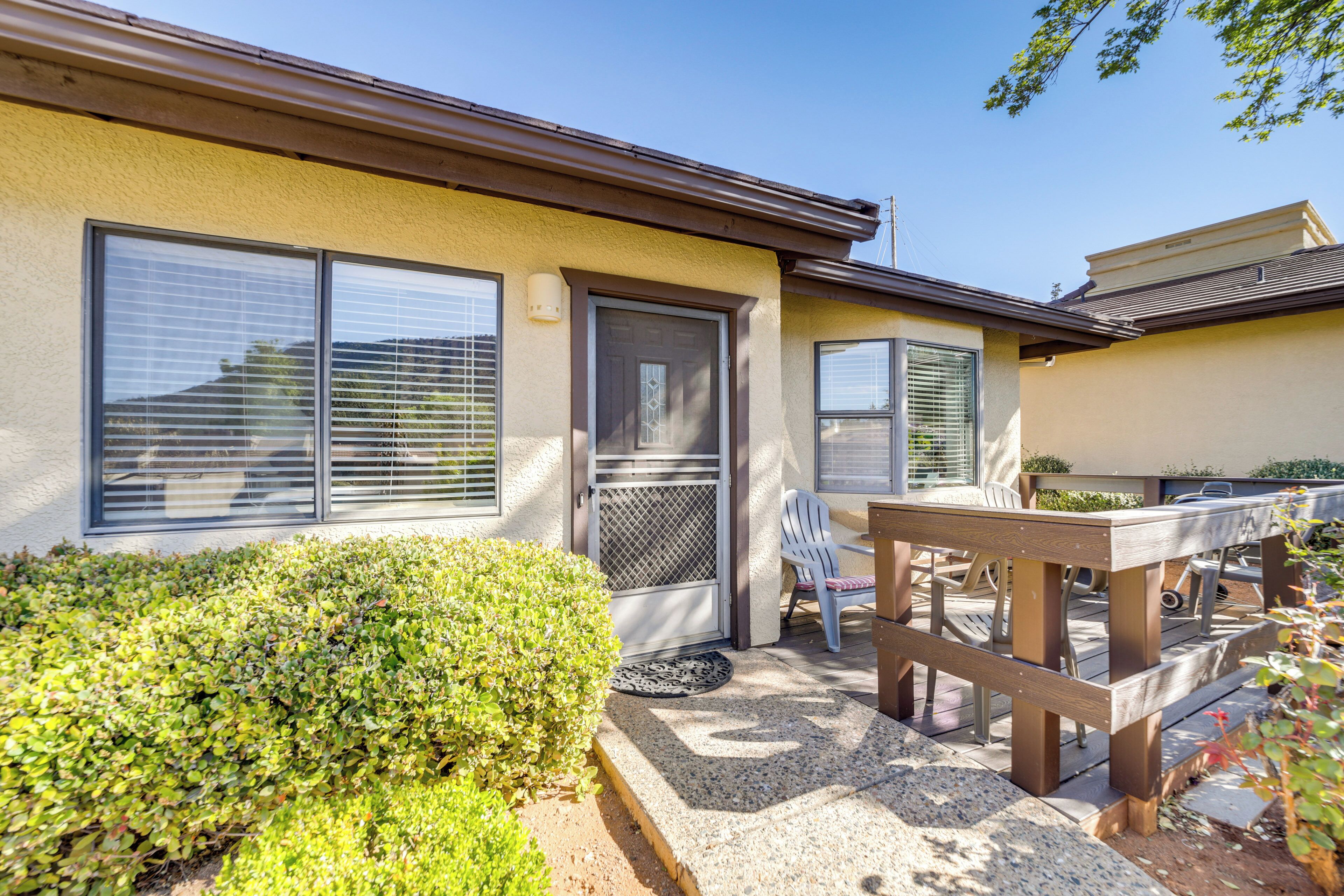 A house with a patio area, a door, and a window with blinds.