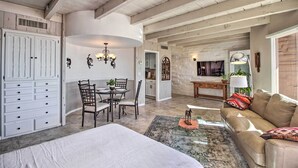 A spacious living area with a high ceiling, a dining table with chairs, a sofa, and a large wardrobe. - Near Golf: Mtn-view Studio in Tucson! (Tucson)