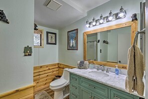 A bathroom with a wooden vanity, a large mirror, and a toilet. - Overgaard Cabin w/ Hot Tub, Fire Pit & Deck! (Overgaard)