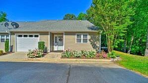 A two-story house with a garage, satellite dish, and a driveway leading to the entrance.
