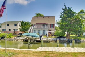 A residential area with a dock, a house with a balcony, and a pond.