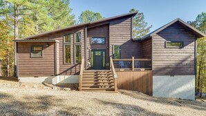 A two-story log cabin with a front porch, a staircase, and a fenced deck area. - Furnished Deck, Hot Tub! Family Gem in Broken Bow (Broken Bow)