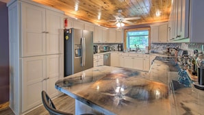 A spacious kitchen with white cabinets, a large island, and a wooden ceiling. - Kayaks & Boat Dock: Lakeside Hot Springs Retreat (Hot Springs Village)