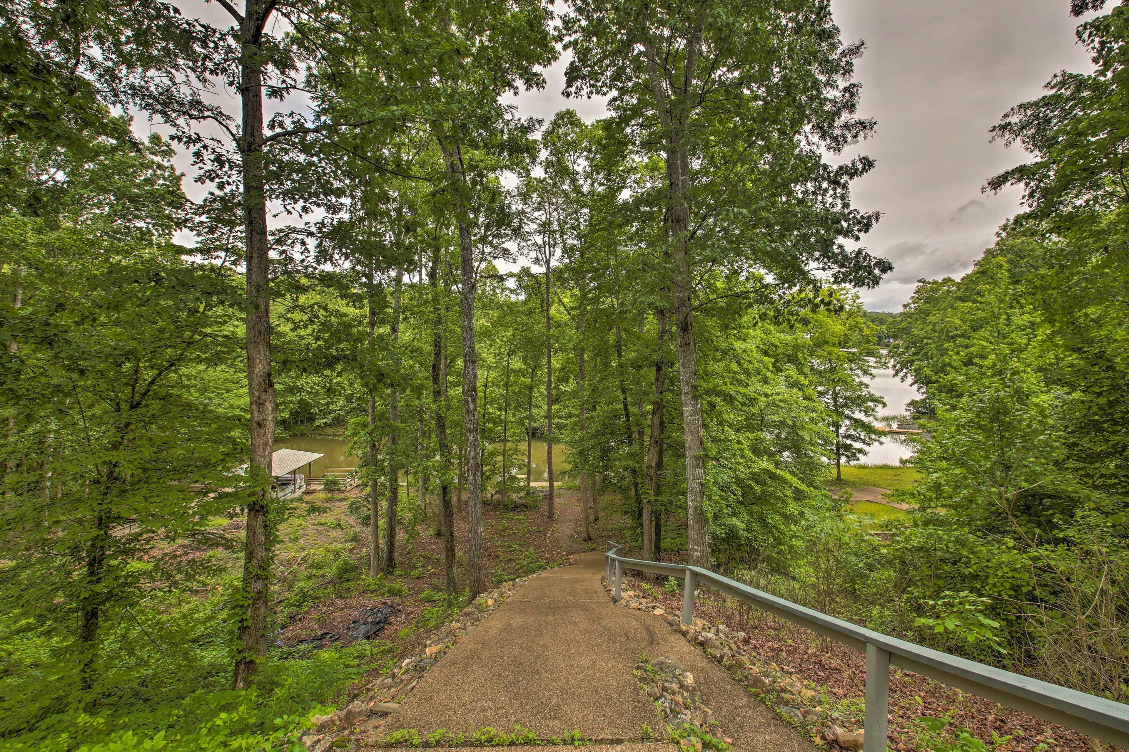 A forested area with a gravel path leading to a building.