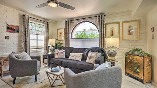 A living room with a dark grey sofa, two armchairs, a coffee table, and a decorative cabinet with floral artwork. - Lovely Green Valley Abode w/ Community Pool! (Green Valley)
