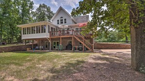 A two-story house with a covered patio and a wooden deck.